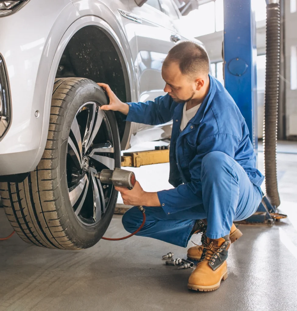 Technician changing a car tire in a garage