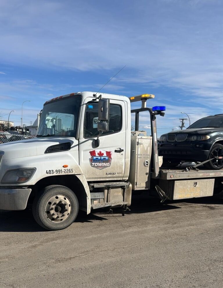 BP Towing flatbed tow truck with a vehicle loaded