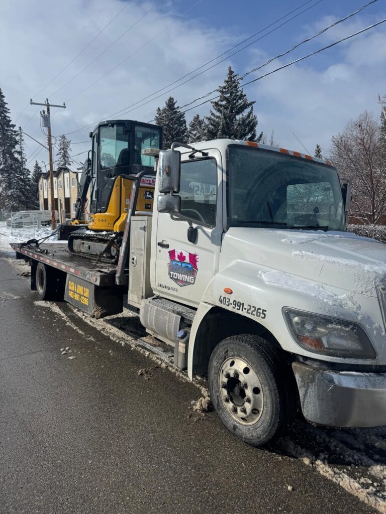 Mini excavator transported on a BP Towing flatbed in Calgary