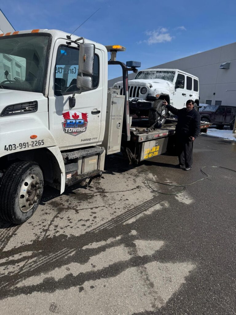 BP Towing flatbed carrying a white Jeep in Calgary