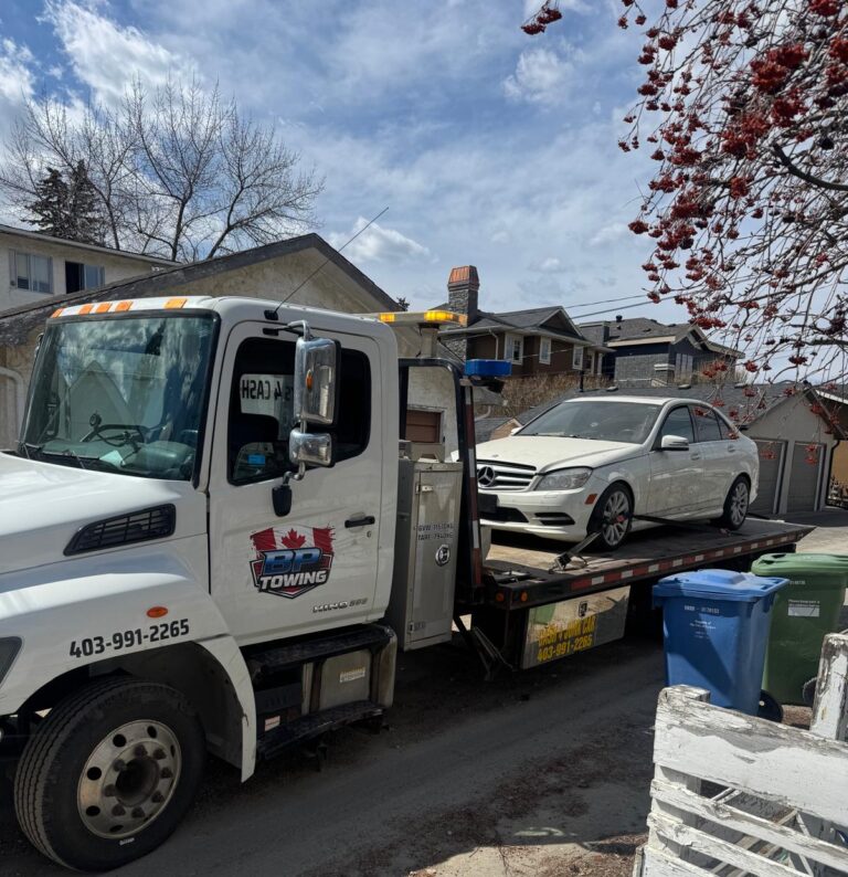 BP Towing flatbed carrying a white Mercedes sedan in Calgary
