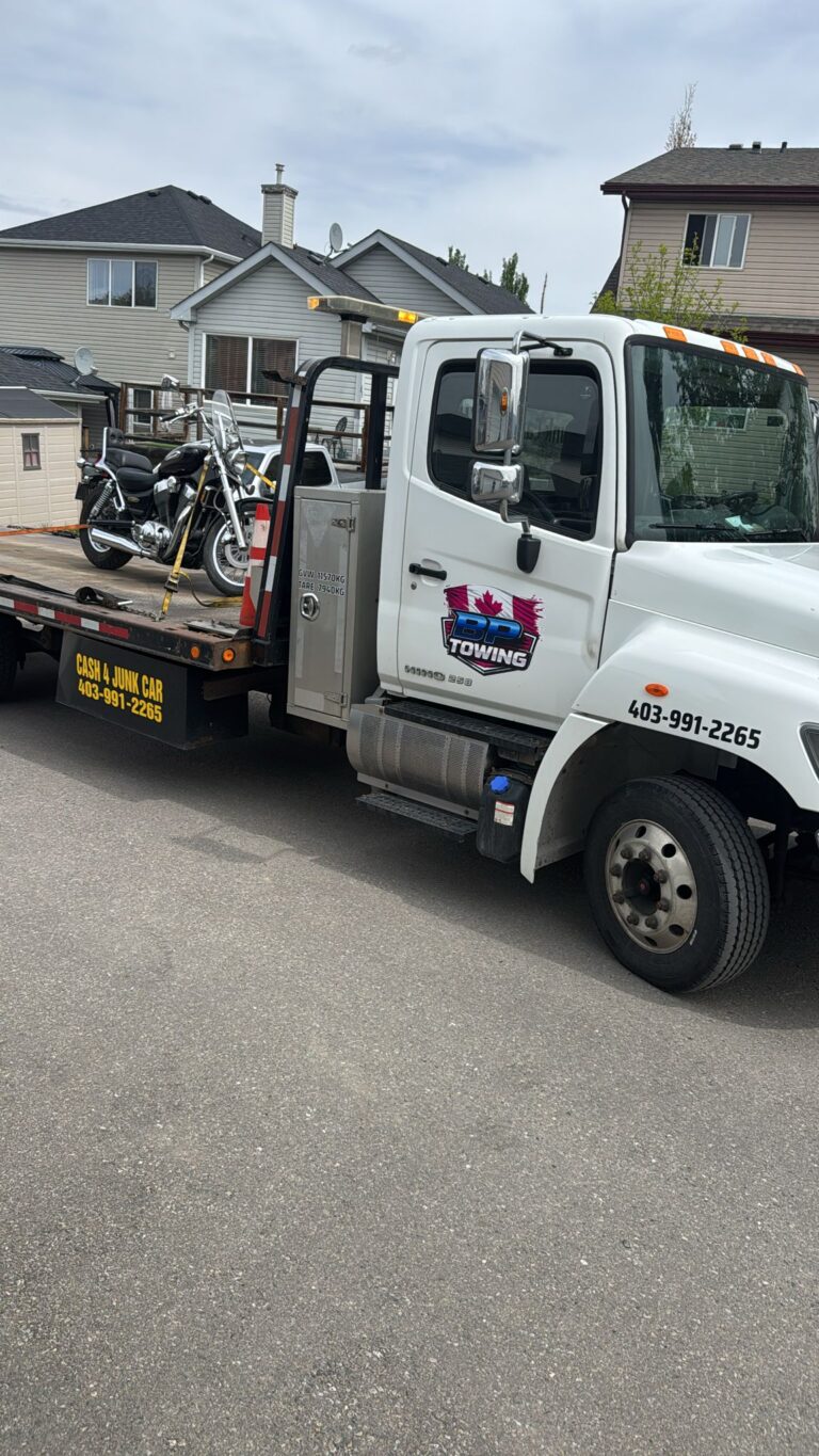 BP Towing flatbed with a motorcycle loaded on a residential street