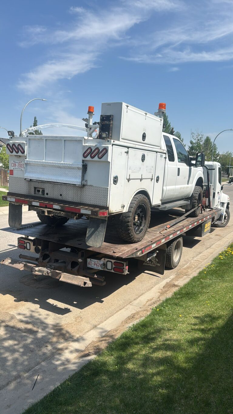 Service truck loaded on a BP Towing flatbed in a residential street