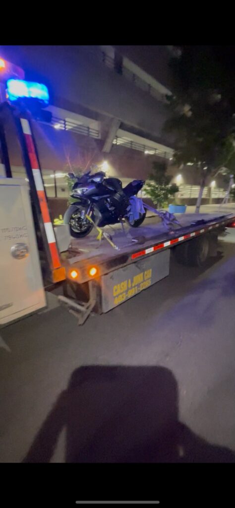 Motorcycle secured on a BP Towing flatbed at night