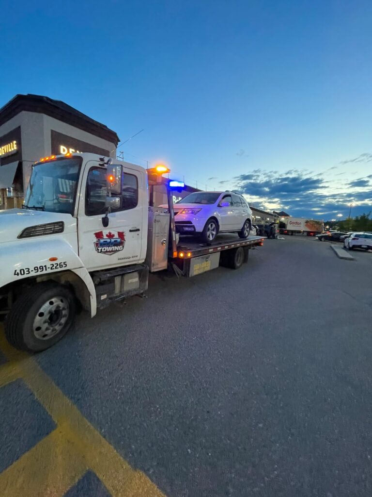 BP Towing flatbed with a white SUV at dusk in a Calgary parking lot