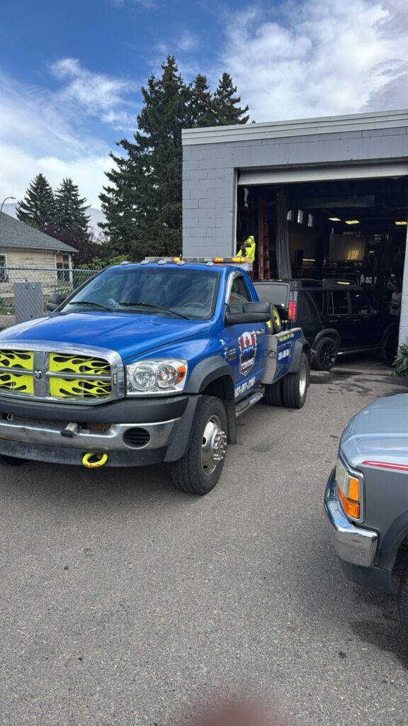 Blue BP Towing wrecker parked outside a Calgary auto shop